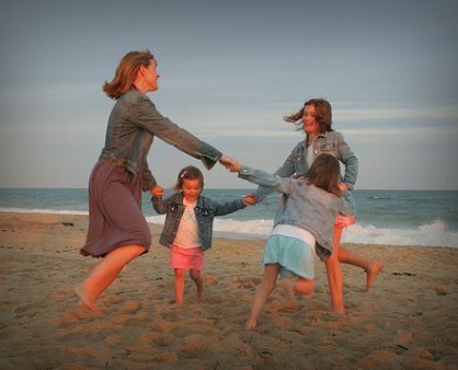 Mãe e crianças a brincar na praia